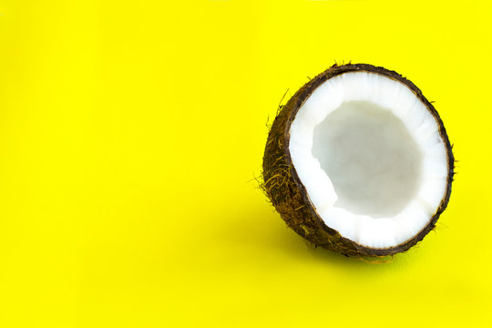 Coconat on a yellow background. Minimalism concept. Trendy minimal summer style.