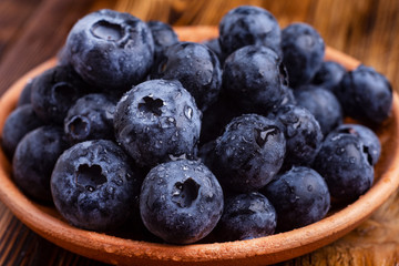 bog whortleberry in a pottery on a wooden table