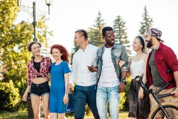 Leisure, holidays, friendship and youth concept. Happy multiracial friends dressed in casual summer...