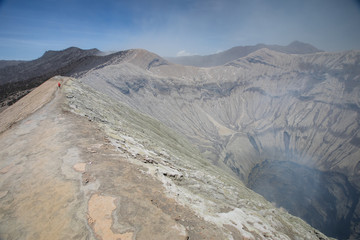 Mount Bromo crater rim trail with some smoke emitting in East Java, Indonesia