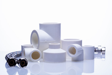 set of fittings for PVC pipes and reinforced water hose on a white background