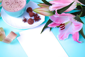 coffee, chocolate, white sheet, flower lily. objects on a bright blue background. copy space.