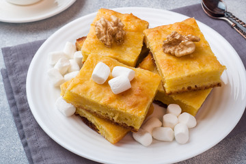 Pieces of delicious pumpkin pie with marshmallow and nuts on a plate.