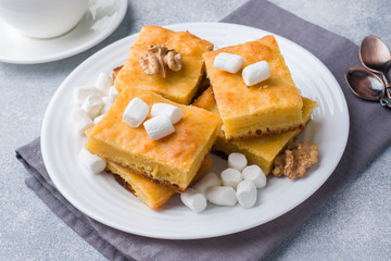 Pieces of delicious pumpkin pie with marshmallow and nuts on a plate.