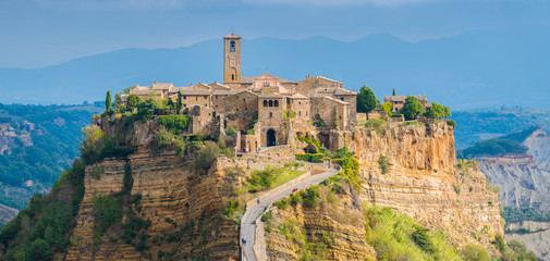 The famous Civita di Bagnoregio hit by the sun on a stormy day. Province of Viterbo, Lazio, Italy. - obrazy, fototapety, plakaty