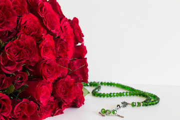 rosary beads and red roses on the white background for Islamic concept. Holy book Koran for Muslims holiday, Ramadan,blessed Friday message and three months