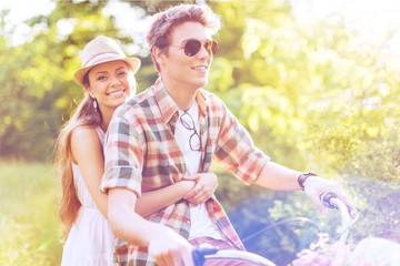 Young beautiful couple riding bikes in summer