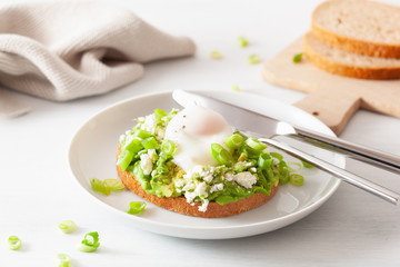 breakfast avocado sandwich with poached egg and feta cheese