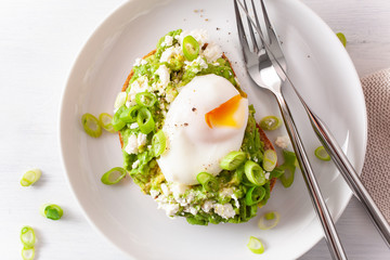 breakfast avocado sandwich with poached egg and feta cheese