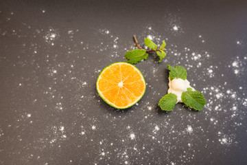 Slice of an Orange, creme and mint. Isolated over black background and white powder