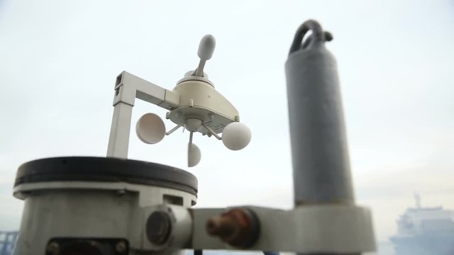 Vane anemometer against the sky, on a ship board. Marine weather vane rotates in the direction of the wind, close up.