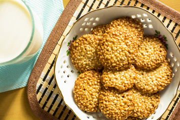 biscuits with sesame seeds and a glass of milk