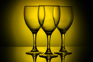 three empty glasses on a yellow background