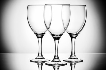 three empty glasses on a reflective surface