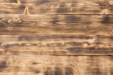 Burned pine planks are located horizontally