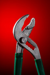 adjustable tongs on a red background