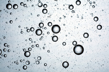 blue background of drops of oil on water