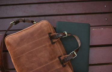 Close up of laptop with leather briefcase on a wooden background - 231022595