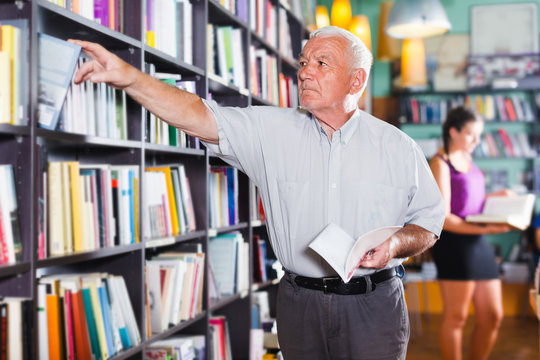 Mature person is choosing book