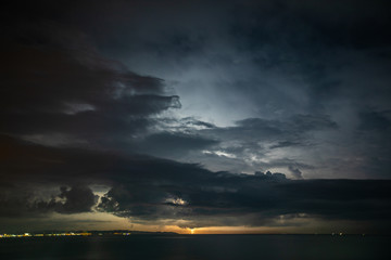 Thunderstorm over the sea, lightning beats the water