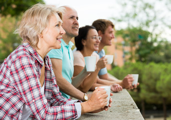 males and females drinking coffee outdoors