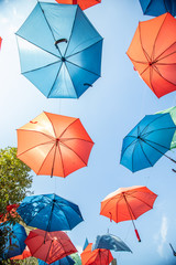 Fototapeta na wymiar Colored umbrellas on the blue sky background