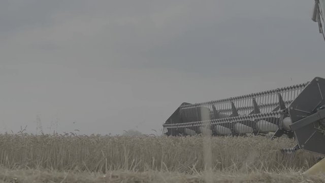 Close up shot of the head of Combine Harvester while it's harvesting Barley - Slowmotion - Log Color