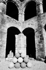Alte Kanonenkugeln aus Stein liegen im Sonnenschein in einem Burginnenhof
