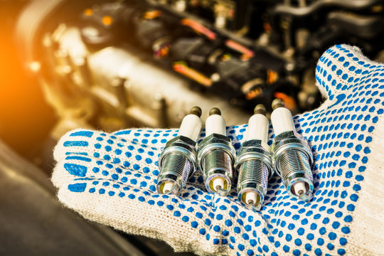 spark plug. car candles are in the hand against the engine.
