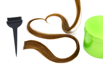 a strand of brown hair in the shape of a heart, brush and container with hair dye on a white background, isolated