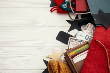 Christmas shopping and seasonal sale. Credit cards and money in wallet, paper bags with clothes, stockings,  tags, gift boxes on rustic wood. Special christmas offer discount. Black Friday