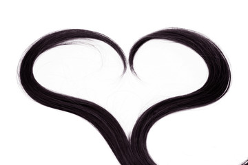 a strand of black hair in the shape of a heart on a white background, isolated