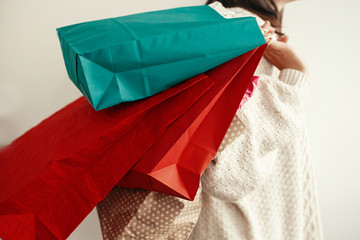 Black Friday. Christmas Sales. Happy Girl carrying colorful shopping bags on white background....
