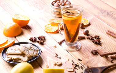 Hot Christmas tea with spices on wood.