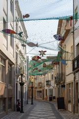 Fototapeta na wymiar A downtown pedestrian street in Aviero, Portugal is decorated with fish net and paper mache sea life.