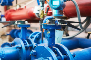 Obraz premium Valves installed on tubes painted blue. Industrial background.