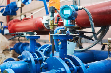 Valves installed on tubes painted blue. Industrial background.