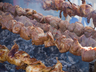 Meat is fried on a spit. Street food grill.