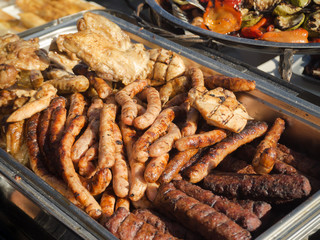 Various grilled sausages on a baking sheet. Street food.