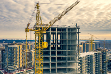 Construction crane next to the house under construction from a height