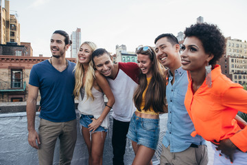 Group of friends spending time together on a rooftop in New york city, lifestyle concept with happy people - obrazy, fototapety, plakaty