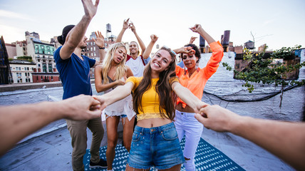 Group of friends spending time together on a rooftop in New york city, lifestyle concept with happy...