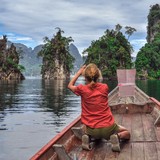 Rear view of woman sitting in boat while traveling