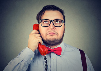 Confused man speaking on phone