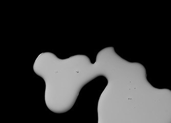 Spilled milk puddle isolated on black background and texture with clipping path, top view