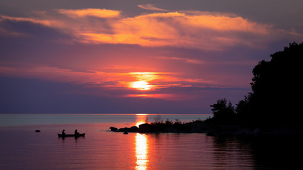 Naklejka na ściany i meble Vibrant Sunset with Silhouette of Trees and Canoe