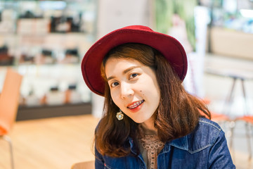 Beautiful Asian women are smiling in jeans. And wearing red hats.