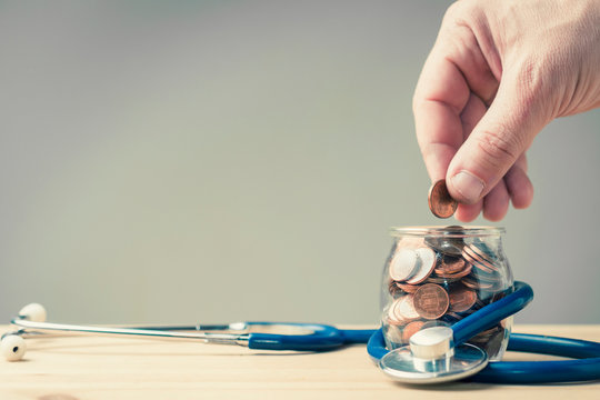 Hand put coin in a jar wrapped in a stethoscope