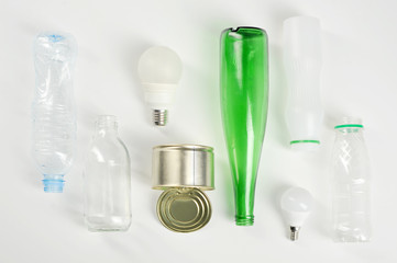 Different types of garbage. Plastic, glass, paper, metal. White background. Close-up. View from above.