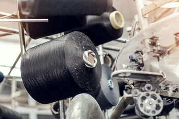 Spools with colored threads on a machine for knitting socks